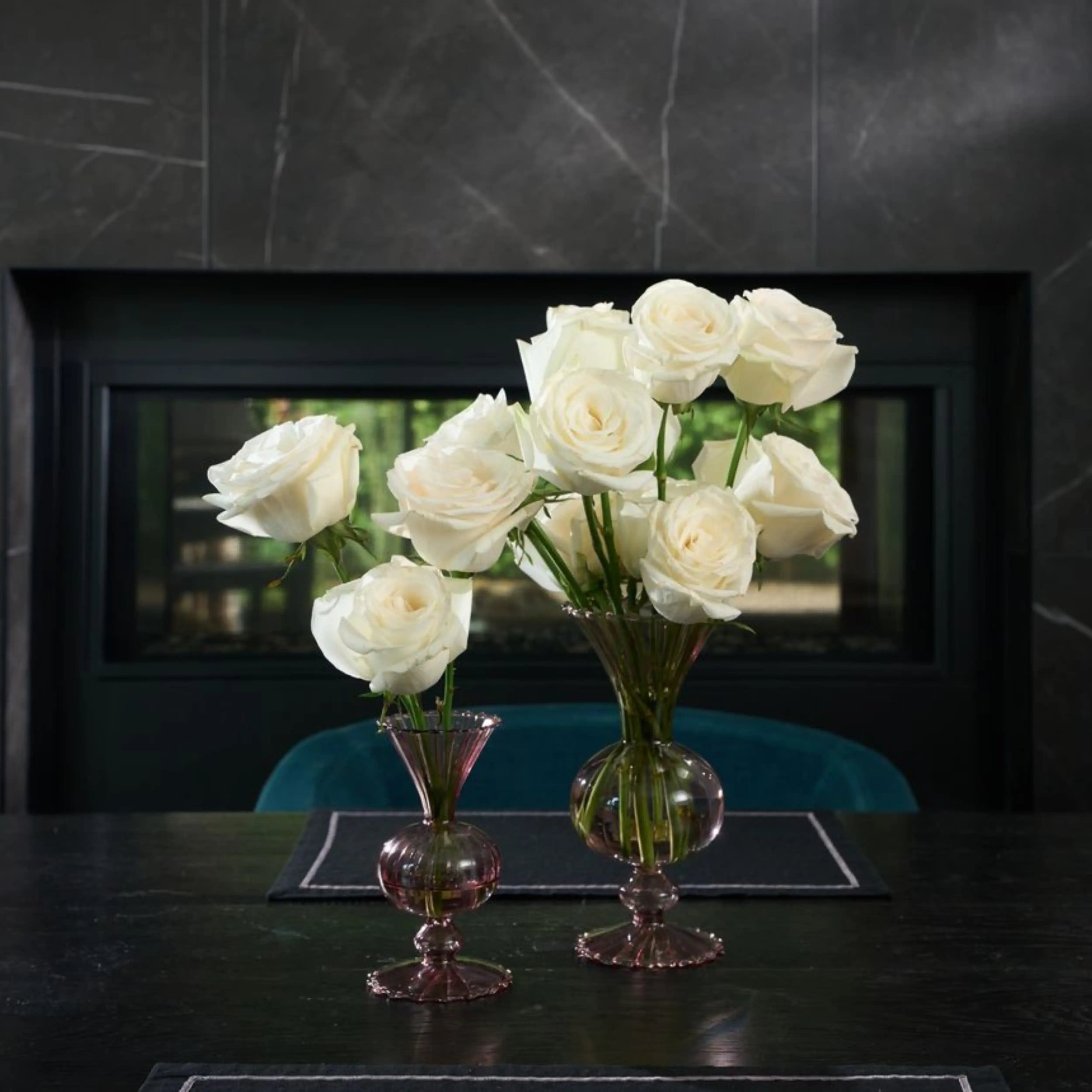 Bouquet of white roses in glass vases on a dark surface with a blurred background