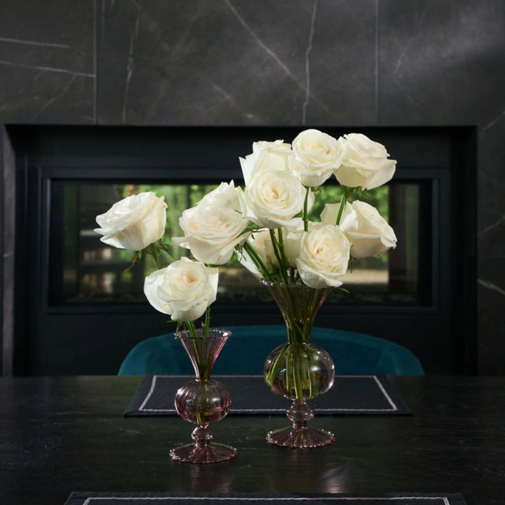 Bouquet of white roses in glass vases on a dark surface with a blurred background