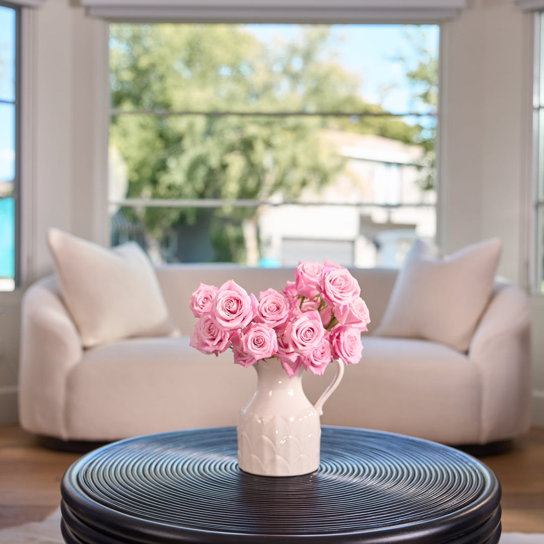 Living room with a vase of pink flowers on a coffee table